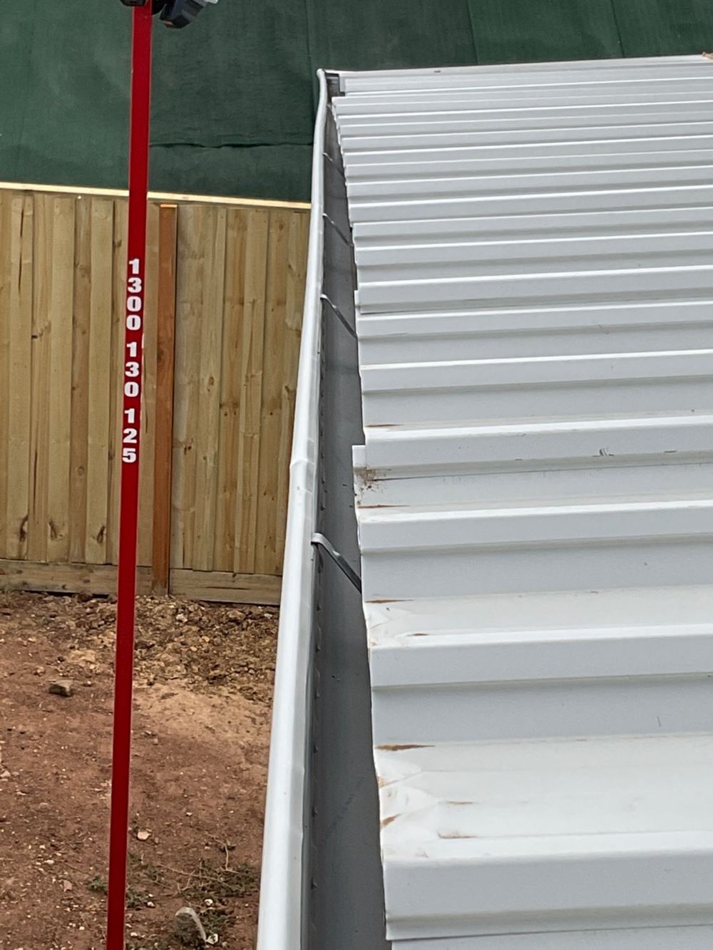 Roof sheets overhanging the gutter by more than 65mm, found during a pre-handover inspection in Bacchus Marsh
